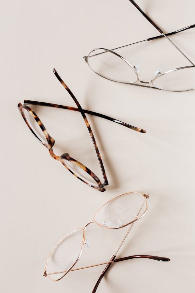 Stylish various eyeglasses on beige background